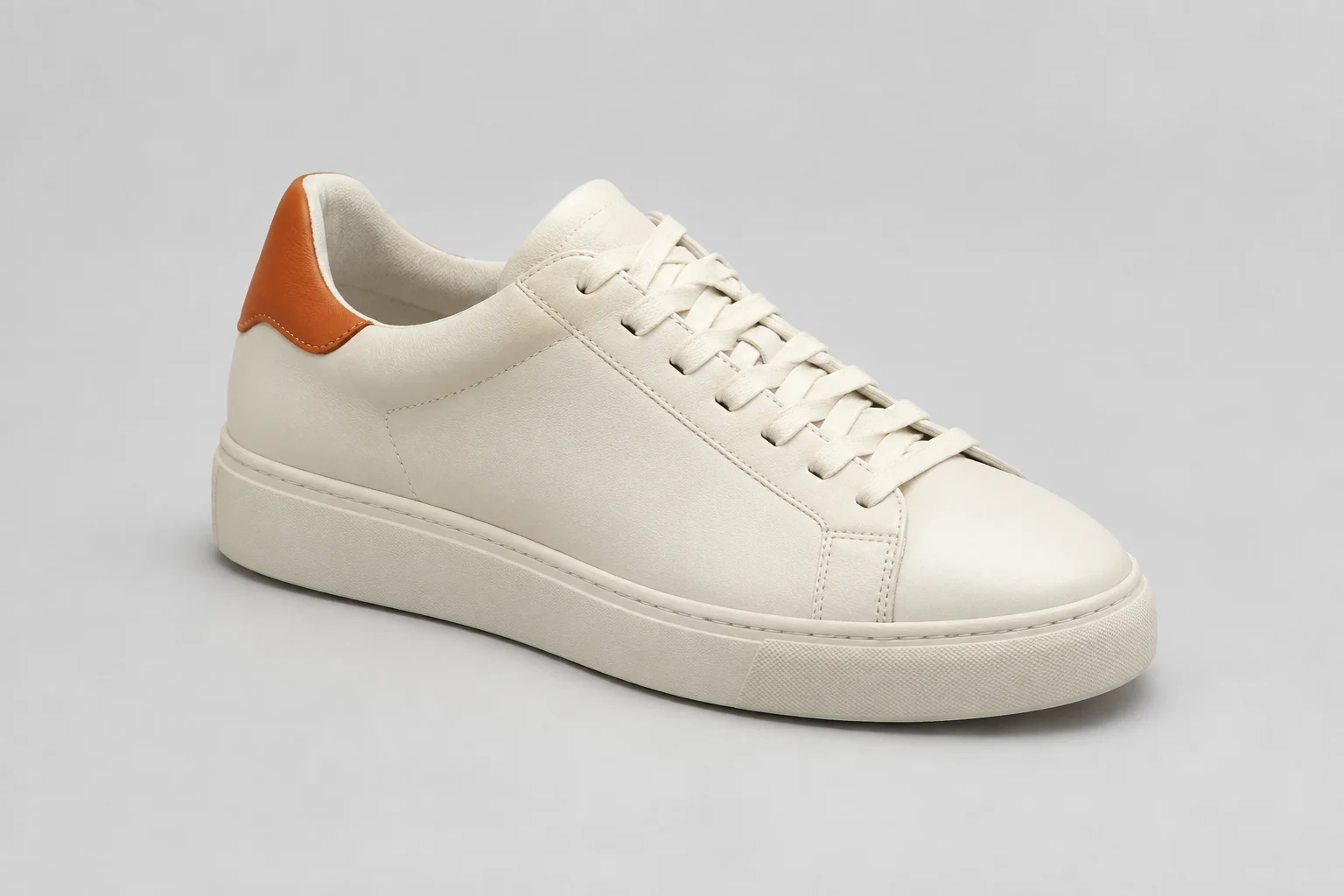 Cream sneaker on a plain studio background before an AI edit