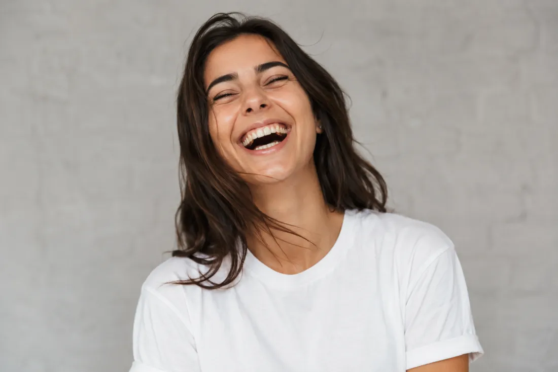 A woman's photo animating from a calm expression into a wide genuine laugh