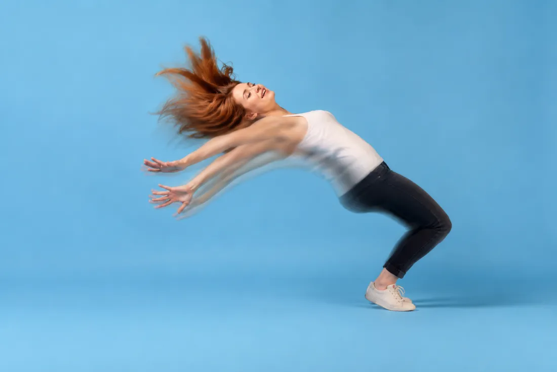 A person springing back from a compressed pose into a rounded bounce