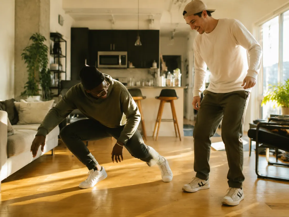 A person laughing while doing a fun, lighthearted dance bit indoors