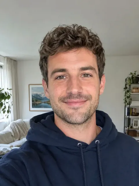 Example input: a smiling man with curly hair in a navy hoodie
