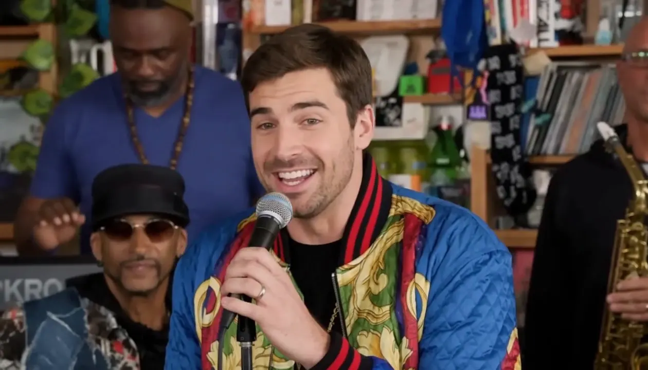 Close-up from the same actual video, new lead singer grinning at the microphone