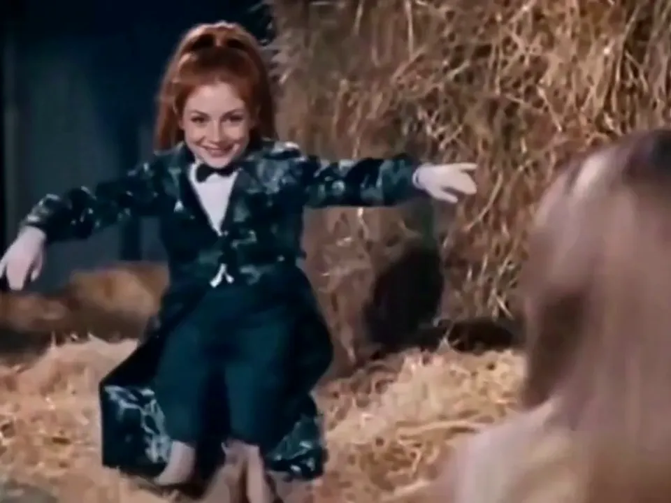 Wide shot of the tip toeing AI dancer spreading his arms in the hay barn
