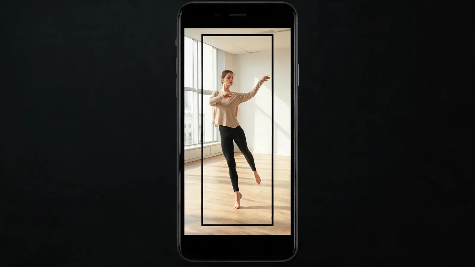 An adult dancer in a modest studio outfit is framed safely within a tall vertical guide on a generic phone