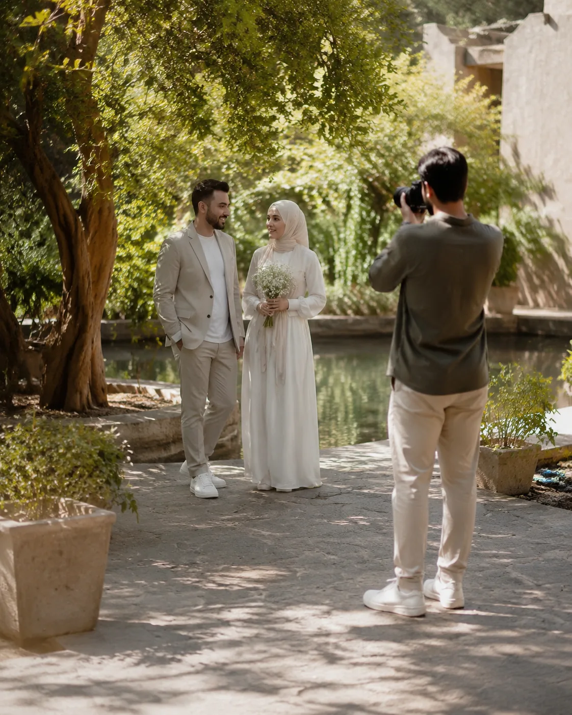 A respectful wedding-video planning scene with a fully clothed adult couple at a distance and a photographer preparing a gentle shot; no readable text