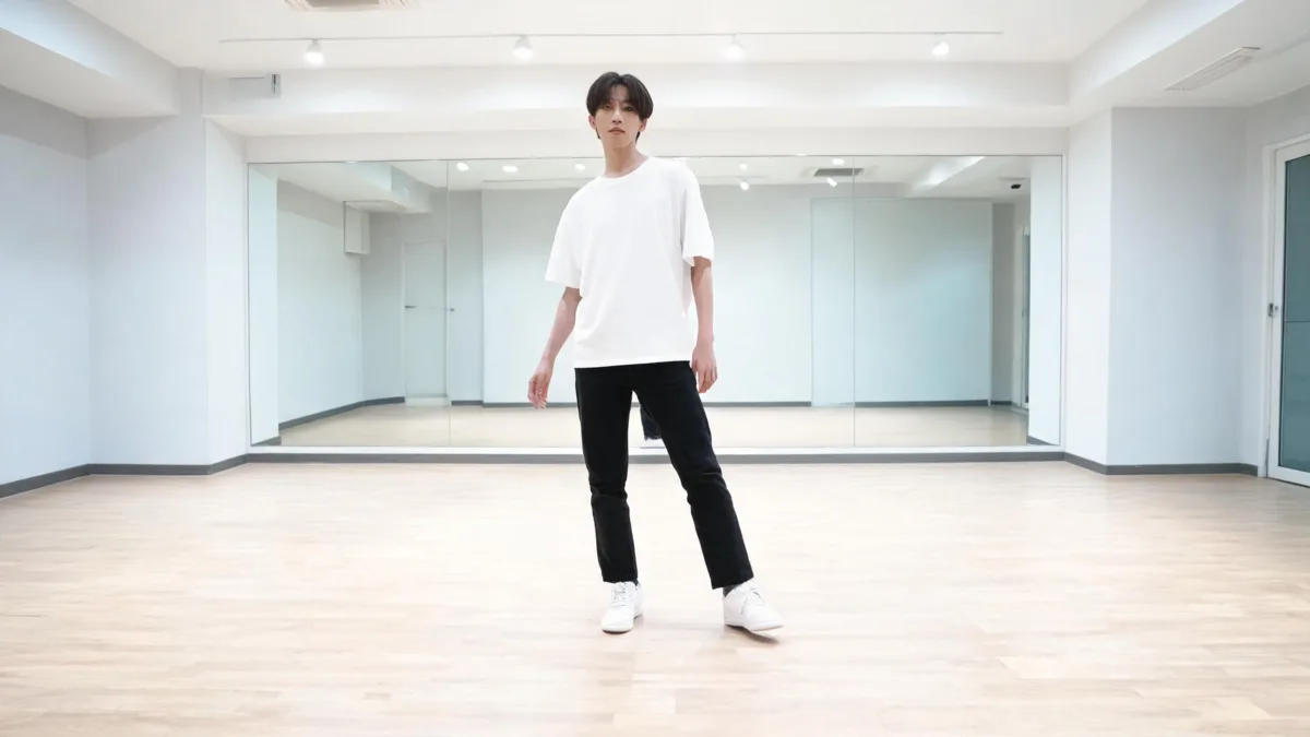 Adult dancer in modest clothing standing full-body in a bright studio as a source-photo reference for an AI K-pop dance video