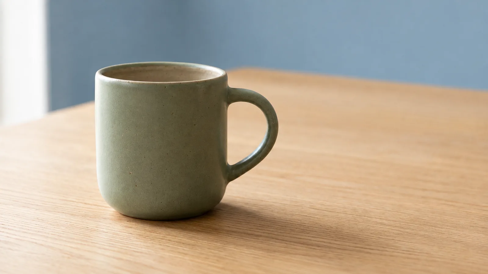Example output of ClipTrend (GPT Image 2.5 Flare): shared green mug reference edited to a dusty-blue wall
